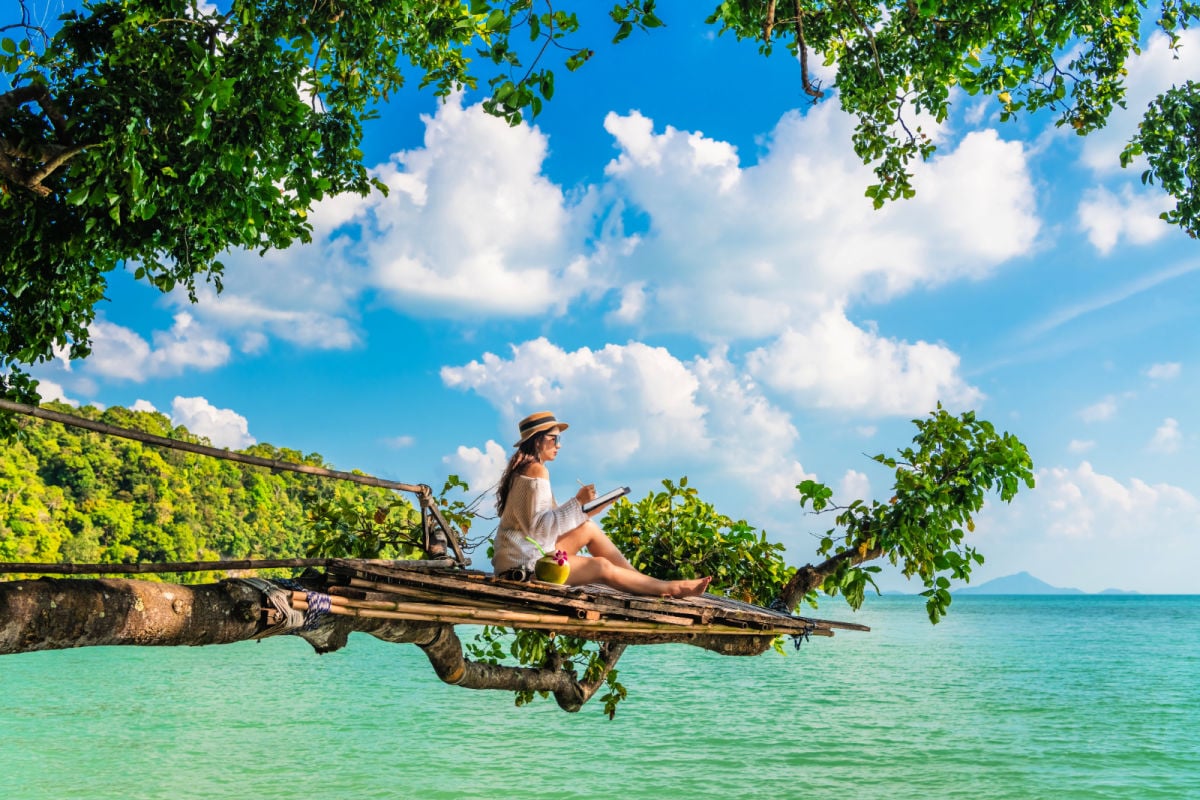 Woman near a beach with a laptop