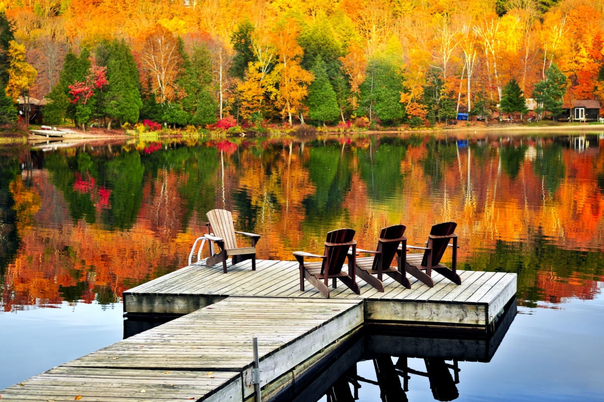 Chairs lakeside amongst vibrant fall foliage